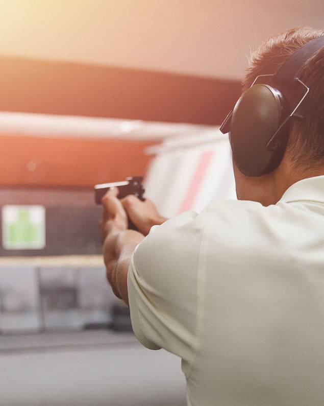 Concealed Carry Safety for Personal Defense Inc - Man shoots pistol in noise protection headphones. Shooting range - CCSPD provides private firearm training sessions for you and your family or friends.
